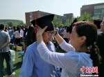 家长为孩子戴“成人帽” 张帆 摄 - 中国新闻社河北分社
