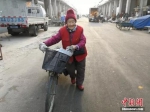 每天她都推着这辆破旧的自行车卖报。李晓伟 摄 - 中国新闻社河北分社