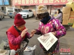 买报的大姐说她刚来佳农市场没多久，一直在买老人的报。李晓伟摄 - 中国新闻社河北分社