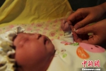 图为医务工作者为女婴戴上“身份”手带。　翟羽佳 摄 - 中国新闻社河北分社