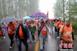 众人冒雨在环陵公路行进。　于俊亮 摄 - 中国新闻社河北分社