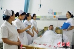 护士长徐慧（右）带领护士查房。　刘丽娟　摄 - 中国新闻社河北分社