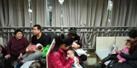 资料图：1月5日，河北省儿童医院呼吸科大厅内，抱着孩童前来看病的父母们摩肩接踵。中新社记者 翟羽佳 摄 - 中国新闻社河北分社