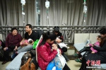 资料图：1月5日，河北省儿童医院呼吸科大厅内，抱着孩童前来看病的父母们摩肩接踵。中新社记者 翟羽佳 摄 - 中国新闻社河北分社