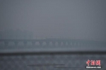 12月1日0时，北京市再启动空气重污染黄色预警，图为一列高铁在雾霾中经过北京房山。 中新社记者 崔楠 摄 - 中国新闻社河北分社