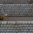 1月10日，唐山海港经济开发区王滩镇秸秆加工企业的工人使用机械设备堆放回收的秸秆。 - 中国新闻社河北分社