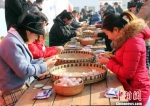 1月13日，正值中国传统节日腊八节，图为游客正在进行剥蒜比赛。　徐巧明 摄 - 中国新闻社河北分社