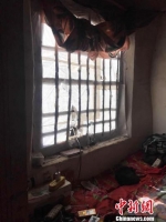 图为梁三片家，窗户上的洞是为了方便猫咪出去抓老鼠。到了睡觉的时候，他用窗帘把窗户封严。　张帆 摄 - 中国新闻社河北分社