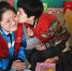 3月5日上午，文安县特教学校的孩子亲吻正给她讲故事的志愿者赵洋。 - 中国新闻社河北分社