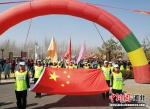 徒步爱好者们在国旗的引领下从清西陵综合服务区出发。 徐巧明 摄 - 中国新闻社河北分社