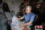 资料图为王汝春在家中阅读报纸。中新社发 刘斧修 摄 - 中国新闻社河北分社
