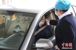 资料图：医务人员使用耳温仪测量车内人员体温。中新社记者 张亨伟 摄 - 中国新闻社河北分社