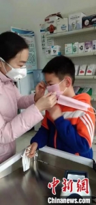药店工作人员为民众免费赠送医用口罩。　刘明明 摄 - 中国新闻社河北分社