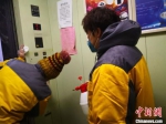 图为石家庄社区工作人员对电梯间进行消毒。　李洋 摄 - 中国新闻社河北分社