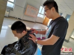 图为老师正在为学生理发。张艳春 供图 - 中国新闻社河北分社