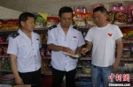 图为林长文(中)和李瑞然(左)在村里的小超市宣传税收优惠政策实施政策扶贫。　于子厚 摄 - 中国新闻社河北分社