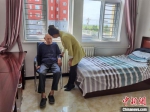 图为席卫琴在养老社区与老人们交谈。　李洋 摄 - 中国新闻社河北分社