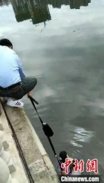 民警把腰带和包接在一起施救 视频截图 - 中国新闻社河北分社