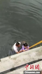 民警和群众合力把女孩拉上岸 视频截图 - 中国新闻社河北分社
