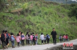 资料图：一名“90后”乡村教师组织学生排队上下学。 中新社记者 瞿宏伦 摄 - 中国新闻社河北分社