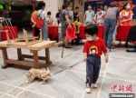 图为一孩童牵着一只会走路的“木头牛”。　翟羽佳 摄 - 中国新闻社河北分社