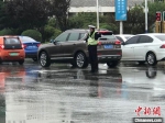 图为秦皇岛交警在雨中指挥交通。河北省交管局供图 - 中国新闻社河北分社