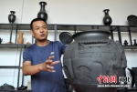 图为刘小伟正在介绍名叫“古韵雄安印象”的黑陶工艺品。 韩冰 摄 - 中国新闻社河北分社