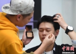 资料图：男性化妆师在为男模特化妆。 - 中国新闻社河北分社