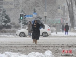 资料图：11月19日，吉林长春，市民冒雪出行。当日，吉林长春遭遇暴雪天气。 中新社记者 刘栋 摄 - 中国新闻社河北分社