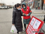 李云凤(右)正在引导出入居民扫健康码。 涞水县妇联供图 - 中国新闻社河北分社