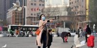3月4日，河北石家庄，家长和孩子在广场上与鸽子嬉戏。中新社记者 翟羽佳 摄 - 中国新闻社河北分社