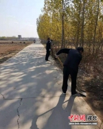 村民正在清理道路两旁垃圾。 程尚梅 摄 - 中国新闻社河北分社