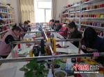 工人们正在编织手绳。 王斌 摄 - 中国新闻社河北分社