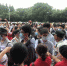 资料图：2020年全国高考期间，上海某考场外，老师们穿着红色T恤站在考场入口处为考生们送上祝福。　叶颖 摄 - 中国新闻社河北分社