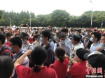 资料图：2020年全国高考期间，上海某考场外，老师们穿着红色T恤站在考场入口处为考生们送上祝福。　叶颖 摄 - 中国新闻社河北分社