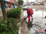 图为易县住建局工作人员对雨后的街道进行清理维护。　刘敬 　摄 - 中国新闻社河北分社