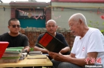 老党员耿栓群(右)在给村里人讲述记事本上记录的大事。　宋杰 摄 - 中国新闻社河北分社