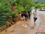 图为村民正在清理泥石路障。　徐巧明 摄 - 中国新闻社河北分社