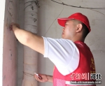 志愿者在清理楼道小广告。 张明月 摄 - 中国新闻社河北分社