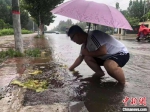 图为邱县政府工作人员雨中坚守。　霍飞飞 摄 - 中国新闻社河北分社