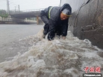 图为邯郸冀南新区防汛一线应急人员冒雨排除险情。　钱磊 摄 - 中国新闻社河北分社