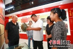 张会申（左一）在军事国防教育展馆进行讲解。 柴更利 摄 - 中国新闻社河北分社
