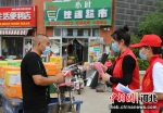 志愿者们向小区居民发放防疫宣传资料。张旭宁 摄 - 中国新闻社河北分社