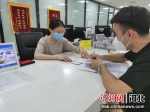 工作人员在协助办事人员填写材料。 定兴县行政审批局供图 - 中国新闻社河北分社
