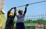 资料图：钢筋工人冒着酷暑施工。 韩苏原 摄 - 中国新闻社河北分社