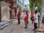 志愿者正在清洗商铺门面。　郝晓东 摄 - 中国新闻社河北分社