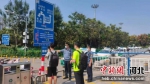 在衡水火车站维持出租车市场秩序并引导乘客扫码乘车。 供图 - 中国新闻社河北分社