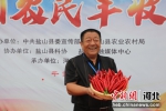 种植带头人刘春江现场展示丰收的新品种羊角辣。供图 - 中国新闻社河北分社