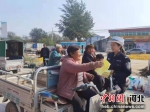 图为交警正在发放交通安全知识宣传资料。 供图 - 中国新闻社河北分社