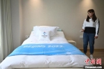 智能床上铺着印有北京2022年冬奥会会徽和吉祥物“冰墩墩”的床上用品。　翟羽佳 摄 - 中国新闻社河北分社